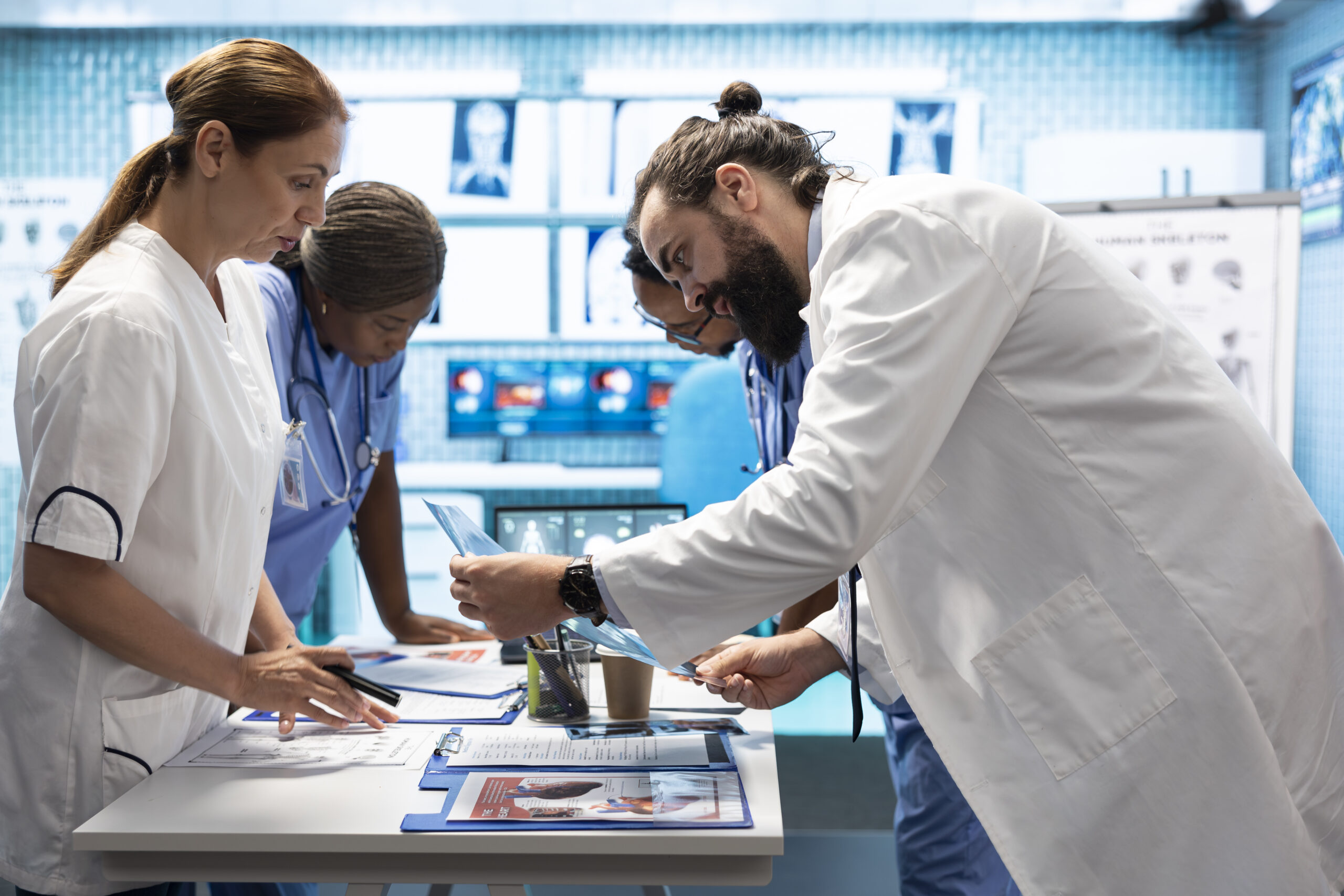 Medic discuss human anatomy scans in a radiology diagnostic meeting at a treatment center, teamwork and expertise in analyzing x ray results. Doctors examine hospital records and analytics.