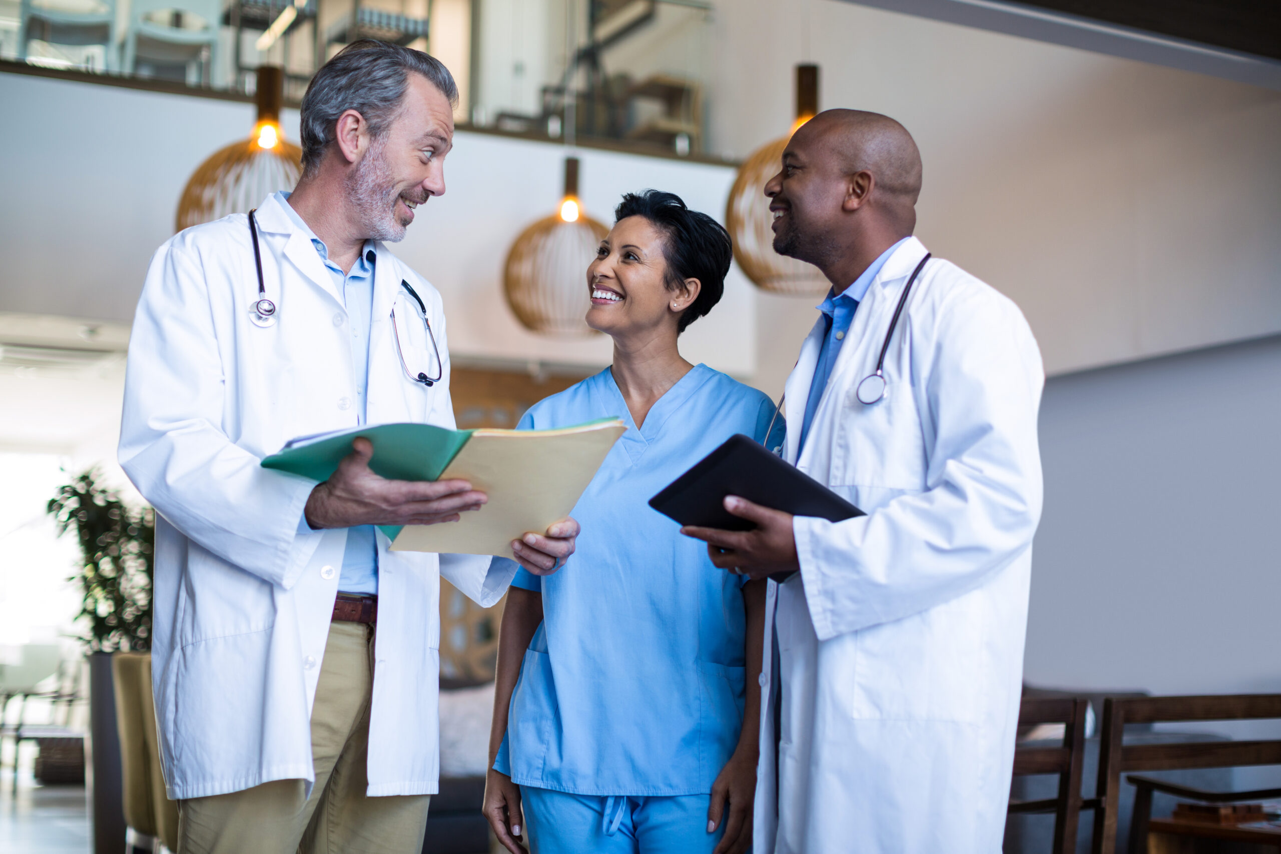 Surgeons and nurse discussing reports of hospital