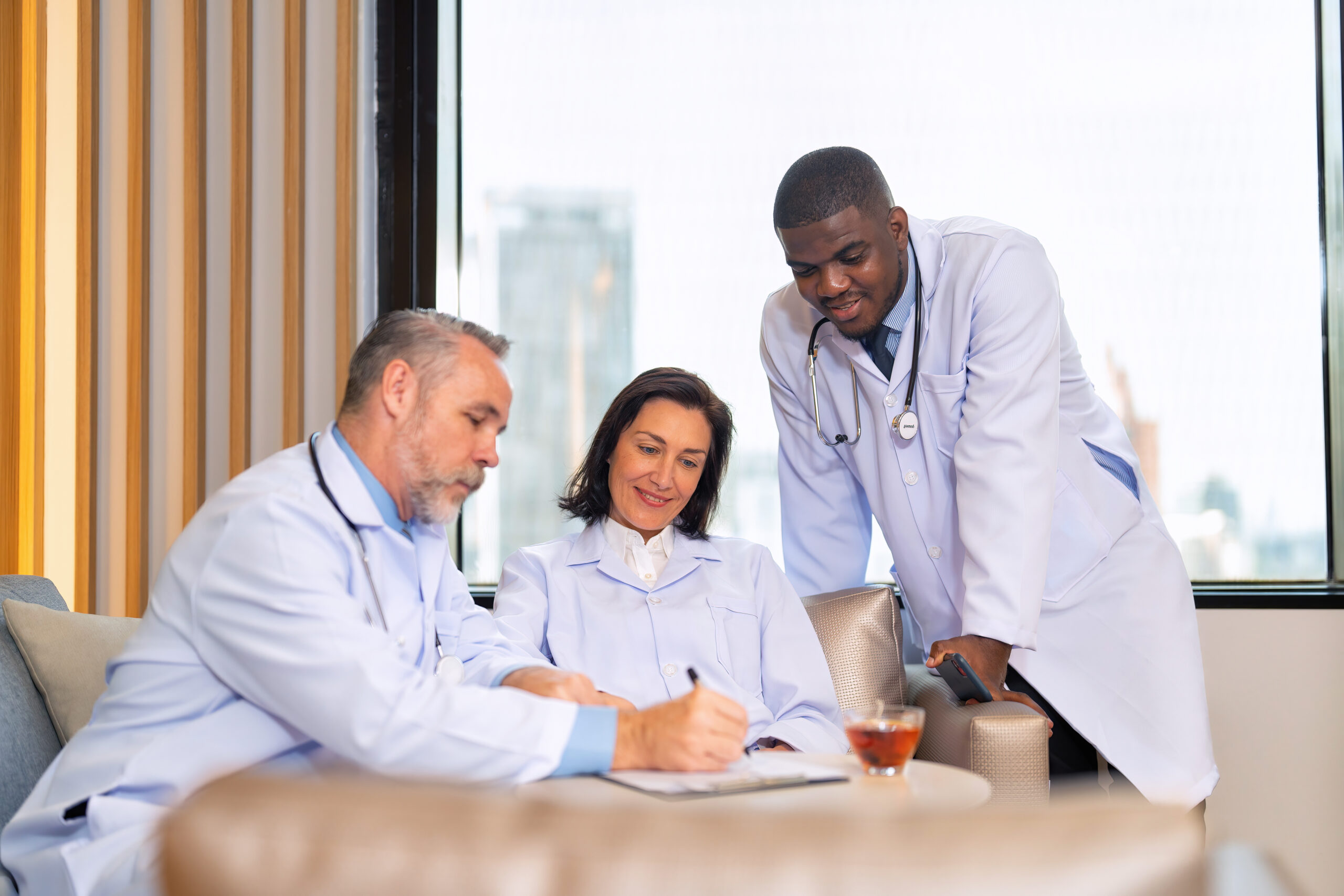 Healthcare doctors sitting on sofa in pantry room at modern hospital relax briefing patient case