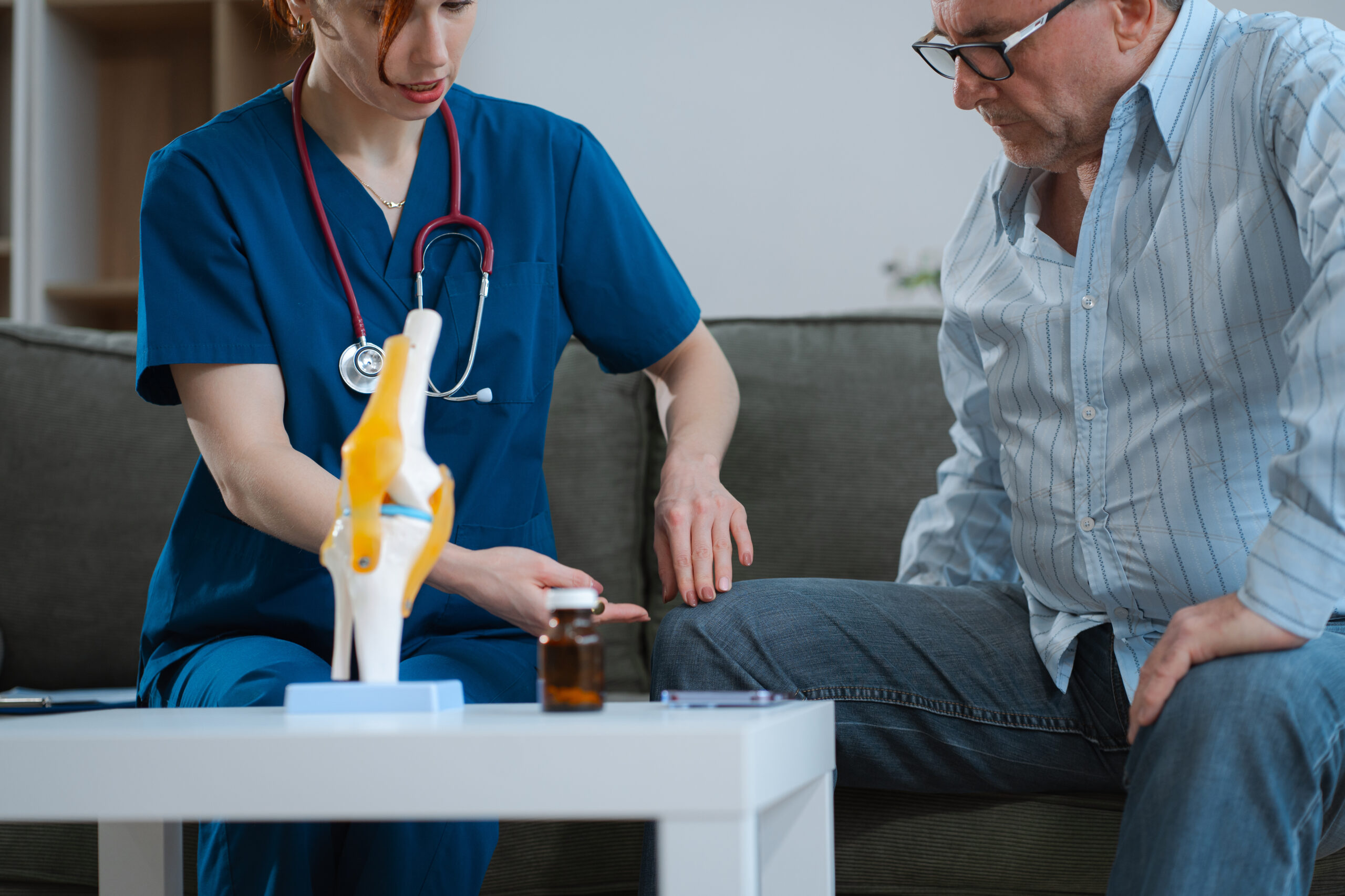 Knee model showing the process of osteoarthritis and knee arthroplasty, doctors explaining symptoms and treatment to patients.