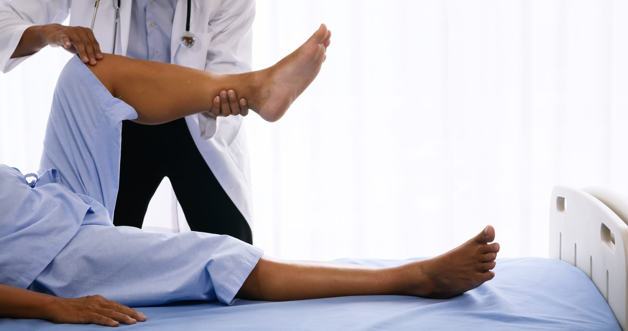 Physical therapist doing physical therapy for adult patient at hospital room.