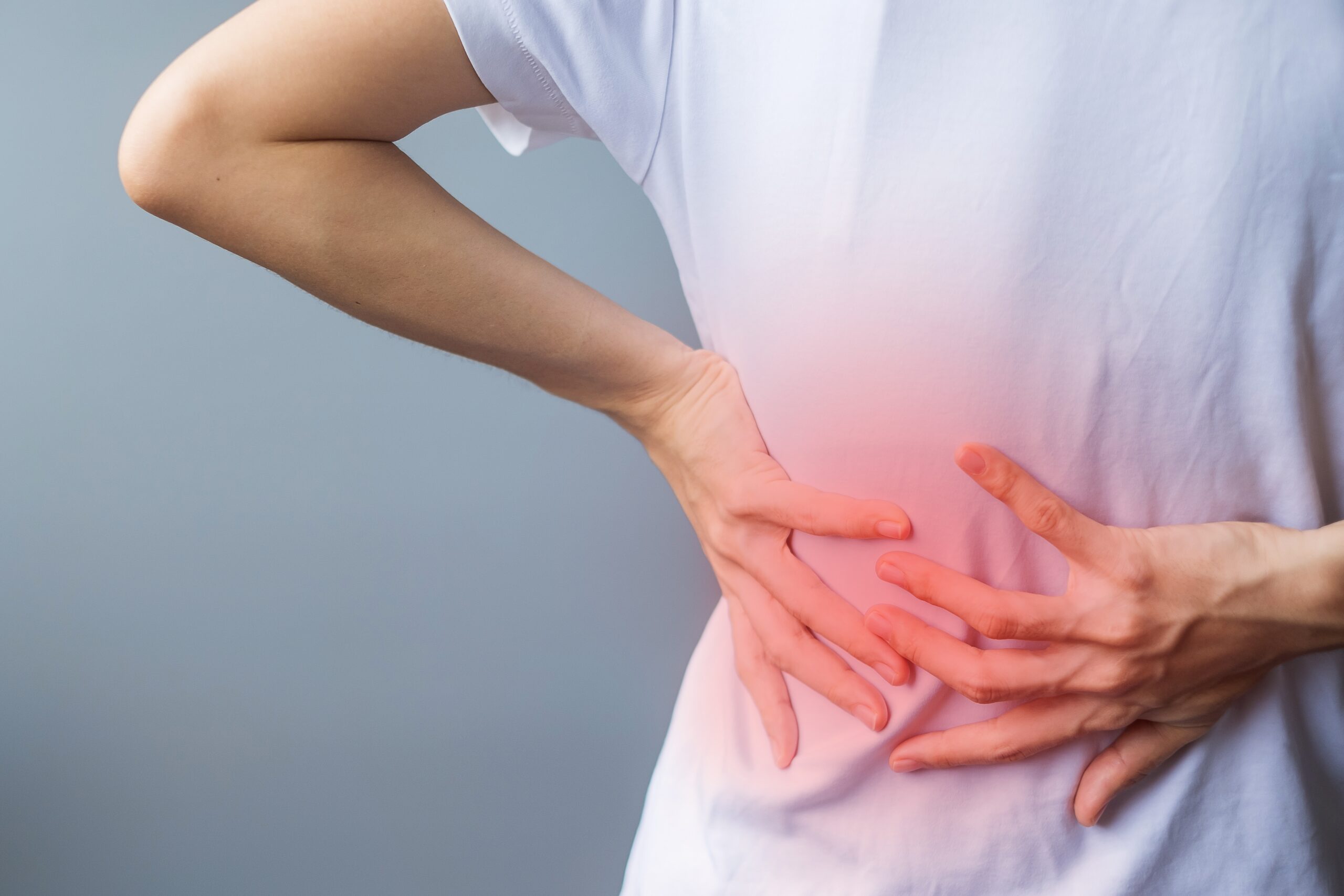 adult female with muscle pain on gray background. Elderly woman having back body ache due to Piriformis Syndrome, Low Back Pain and Spinal Compression. Office syndrome and medical concept